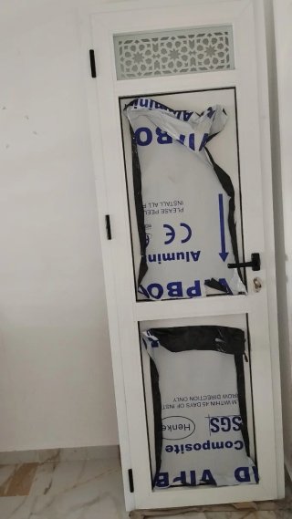 Puerta aluminio baño con reja decorativa
