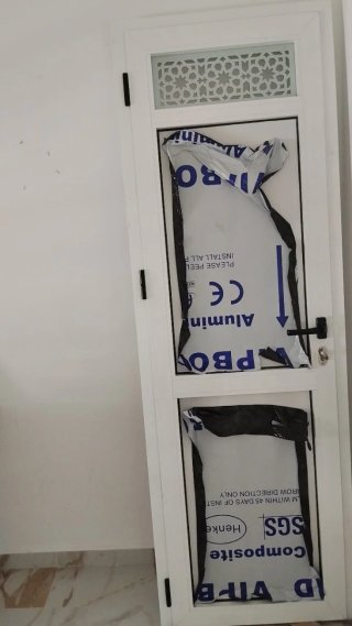 Puerta aluminio baño con reja decorativa