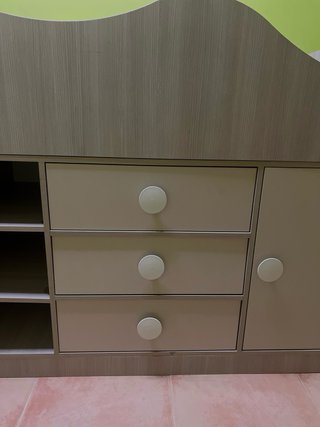Cama infantil compacta con escritorio y cajones.