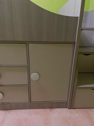Cama infantil compacta con escritorio y cajones.