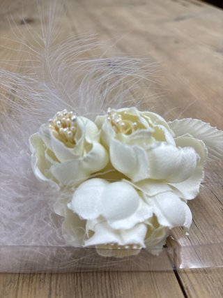 Adorno floral con plumas y perlas