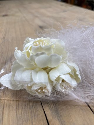 Adorno floral con plumas y perlas