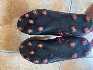 Botas de fútbol Puma negras y naranjas