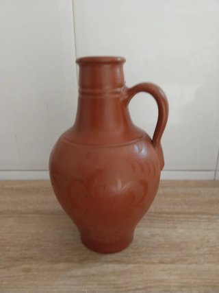 Jarra de cerámica con detalle floral.