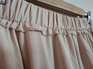 Falda beige fluida con volantes.