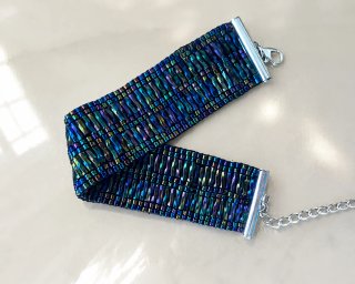 Pulsera brazalete ancha de cuentas iridiscentes.