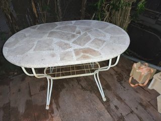 Mesa de jardín ovalada de piedra y metal
