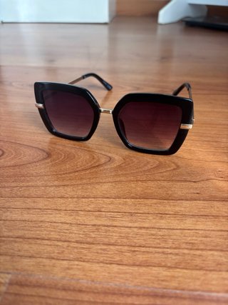 Gafas de sol negras con detalles dorados