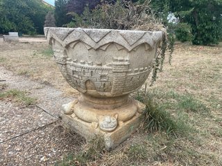 Jardinera de piedra con figuras