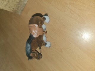 Caballo de peluche marrón con silla
