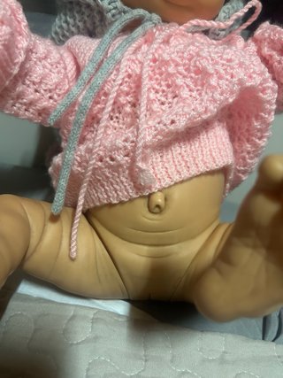 Bebé realista con gorro y jersey rosa