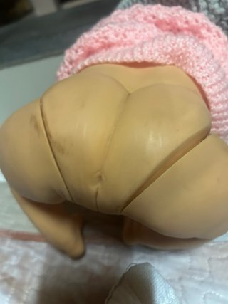Bebé realista con gorro y jersey rosa