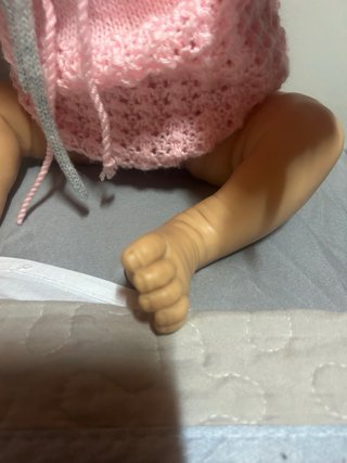 Bebé realista con gorro y jersey rosa