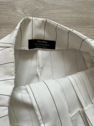 Pantalón blanco de rayas con cinturón.