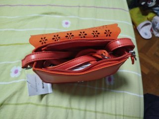 Bolso color coral con flores troqueladas