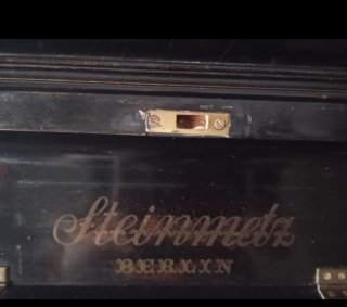 Piano antiguo negro con adornos dorados