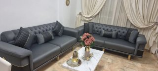 Sofá y sillón gris con detalles dorados modernos.
