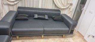 Sofá y sillón gris con detalles dorados modernos.