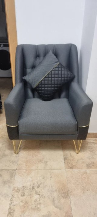 Sofá y sillón gris con detalles dorados modernos.