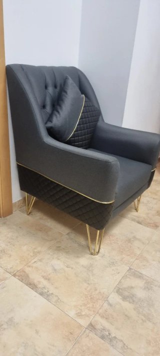 Sofá y sillón gris con detalles dorados modernos.
