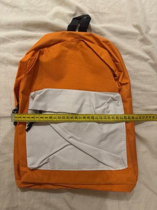 Mochila naranja con bolsillo blanco.