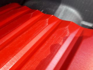 Maleta de viaje roja con ruedas y asa grande.