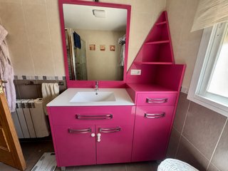 Mueble de baño rosa con lavabo blanco