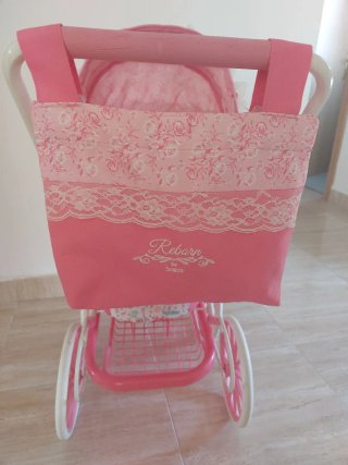 Cochecito de muñecas rosa con encaje