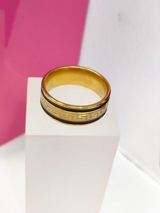 Anillo acero dorado con lineas negras y diseño de greca en
