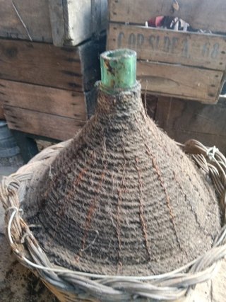 Vecchia damigiana in vetro e vimini
