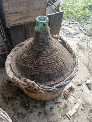 Vecchia damigiana in vetro e vimini