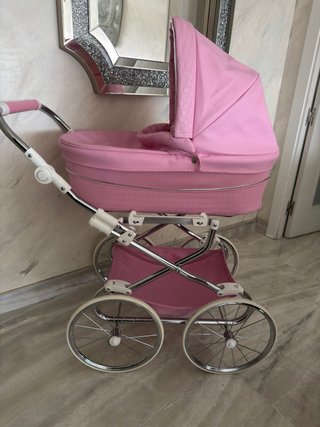 Carro de muñecas rosa con ruedas grandes