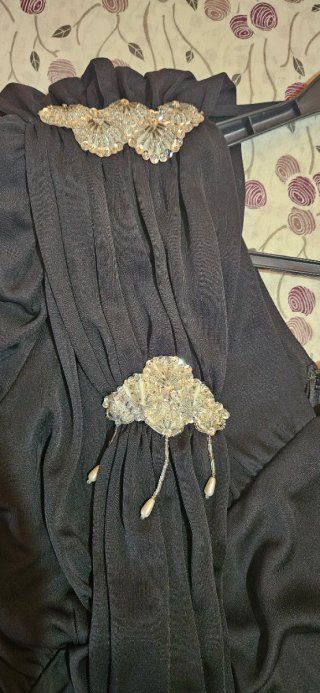 Vestido negro drapeado con broche
