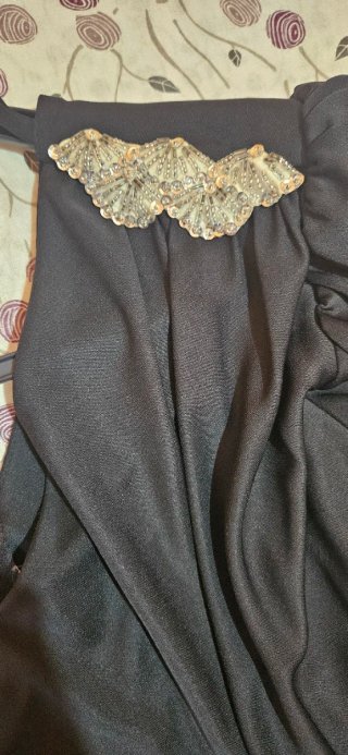 Vestido negro drapeado con broche