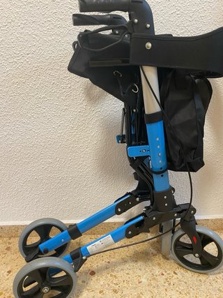 Andador azul con asiento y ruedas .
