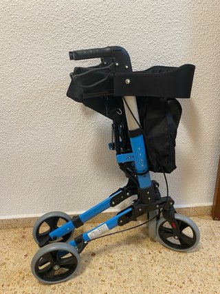 Andador azul con asiento y ruedas .