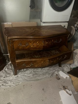 Cómoda de madera con detalles decorativos dorados