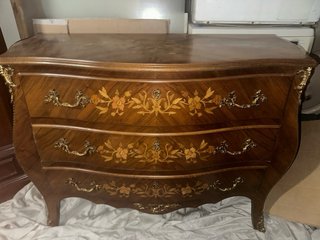 Cómoda de madera con detalles decorativos dorados