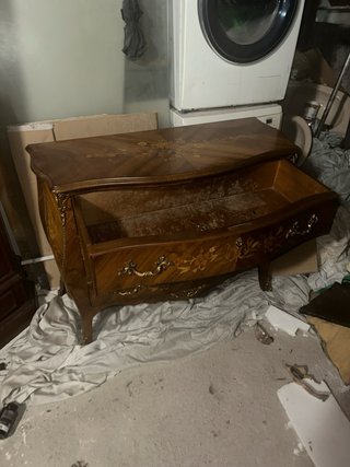 Cómoda de madera con detalles decorativos dorados