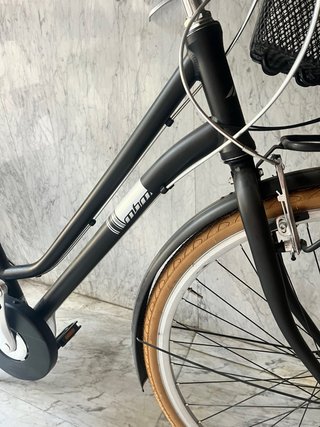 Bicicleta de paseo negra con cesta y portabultos.