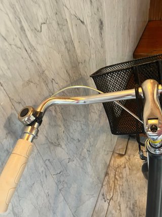 Bicicleta de paseo negra con cesta y portabultos.
