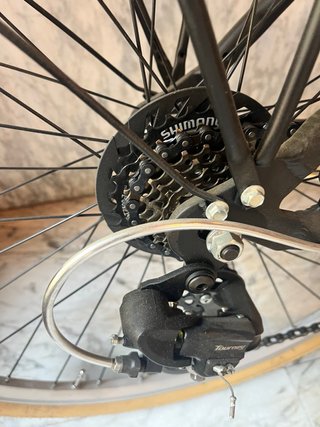 Bicicleta de paseo negra con cesta y portabultos.