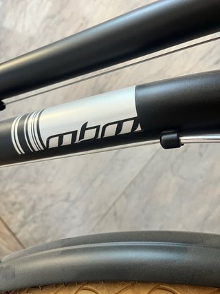 Bicicleta de paseo negra con cesta y portabultos.