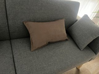 Sofá gris de tela con patas de madera