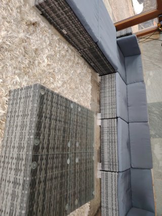 Sofá de mimbre gris con mesa de centro