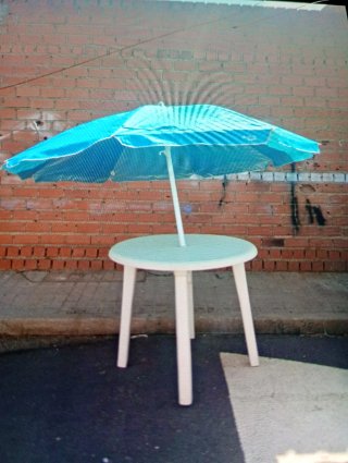 Mesa redonda blanca con sombrilla azul