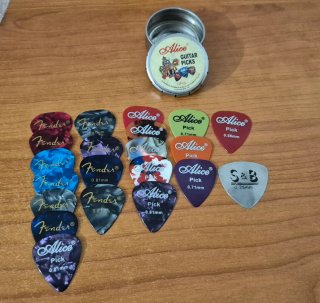 Caja metálica Alice con púas de guitarra