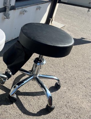 Silla de estética negra con ruedas