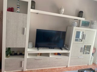 Mueble TV gris y blanco con cristal, y mesas
