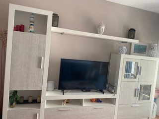 Mueble TV gris y blanco con cristal, y mesas